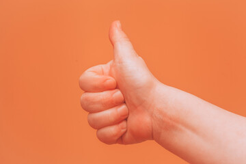 Thumbs up. Like gesture on orange background
