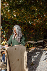 Obraz na płótnie Canvas Mature pale hair stylish woman lifestyle portrait outdoors near cafe