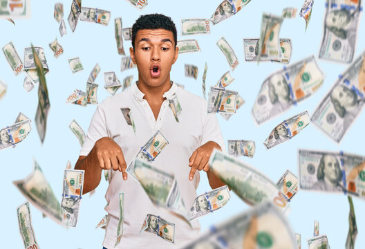 Young arab man wearing casual clothes pointing down with fingers showing advertisement, surprised face and open mouth