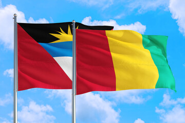 Guinea Bissau and Antigua and Barbuda national flag waving in the windy deep blue sky. Diplomacy and international relations concept.