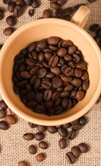 
yellow coffee cup with grains and raffia cloth background
