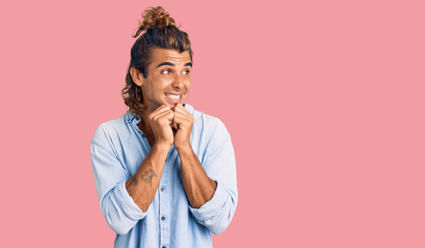 Young hispanic man wearing summer style laughing nervous and excited with hands on chin looking to the side
