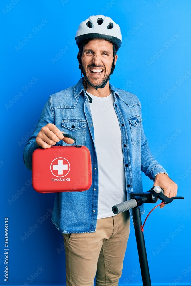 Sticker young man standing on scooter wearing helmet holding first aid kit smiling and laughing hard out lou