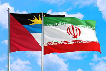 Naklejka na ściany i meble Iran and Antigua and Barbuda national flag waving in the windy deep blue sky. Diplomacy and international relations concept.