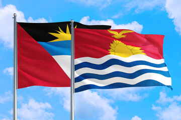 Kiribati and Antigua and Barbuda national flag waving in the windy deep blue sky. Diplomacy and international relations concept.