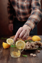 Ginger tea with brown sugar , lemon and mint on old wooden table .