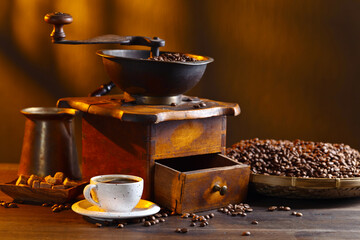 Cup of black coffee , coffee grinder and roasted beans.