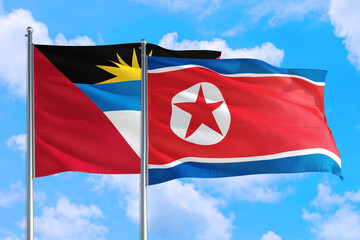 North Korea and Antigua and Barbuda national flag waving in the windy deep blue sky. Diplomacy and international relations concept.