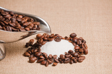 coffee bean on pile of sugar, silver container with coffee and brown background