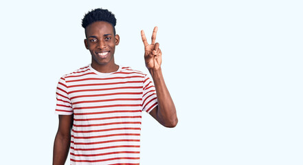Fototapeta premium Young african american man wearing casual clothes showing and pointing up with fingers number two while smiling confident and happy.