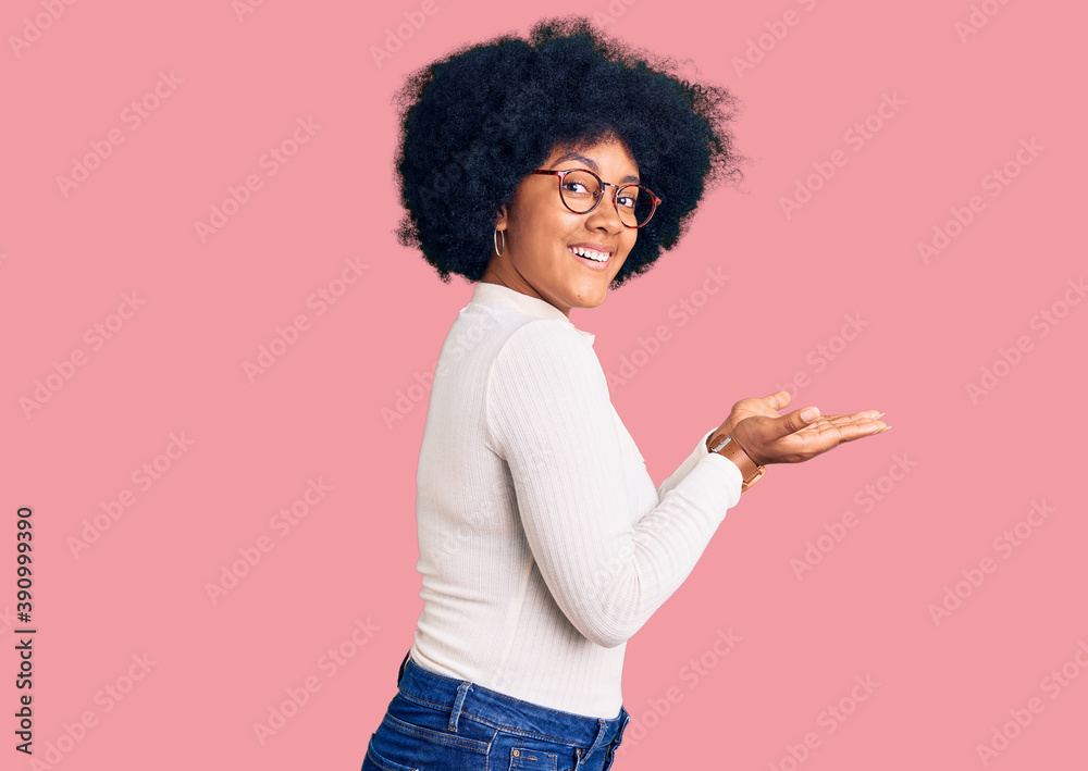 Sticker young african american girl wearing casual clothes and glasses pointing aside with hands open palms 