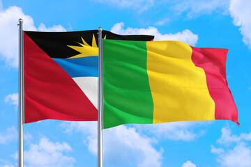 Mali and Antigua and Barbuda national flag waving in the windy deep blue sky. Diplomacy and international relations concept.
