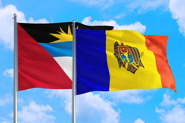 Moldova and Antigua and Barbuda national flag waving in the windy deep blue sky. Diplomacy and international relations concept.