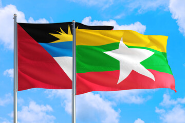 Myanmar and Antigua and Barbuda national flag waving in the windy deep blue sky. Diplomacy and international relations concept.