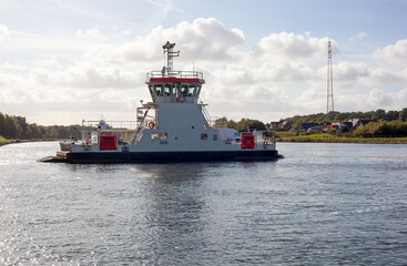 Pusher tug boat floating on the water near a village