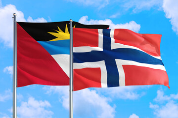 Norway and Antigua and Barbuda national flag waving in the windy deep blue sky. Diplomacy and international relations concept.