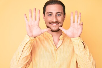 Young handsome man wearing casual clothes showing and pointing up with fingers number nine while...