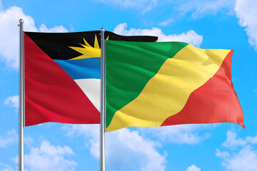 Republic Of The Congo and Antigua and Barbuda national flag waving in the windy deep blue sky. Diplomacy and international relations concept.