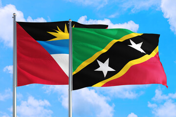 Saint Kitts And Nevis and Antigua and Barbuda national flag waving in the windy deep blue sky. Diplomacy and international relations concept.