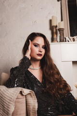 New Year's outfit for a woman. A young woman is dressed in a shiny New Year's outfit. Happy woman with bright makeup
