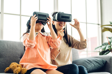 Portrait of enjoy happy love asian family mother and little asian girls child smiling and having fun using glasses of virtual reality headset.concept of modern technologies