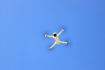 Drone blanc qui vole de ans le ciel bleu