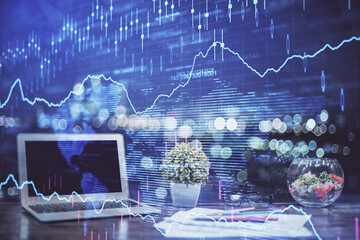 Financial chart drawing and table with computer on background. Double exposure. Concept of international markets.