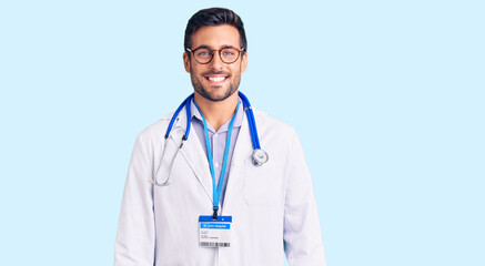 Fototapeta premium Young hispanic man wearing doctor uniform and stethoscope with a happy and cool smile on face. lucky person.