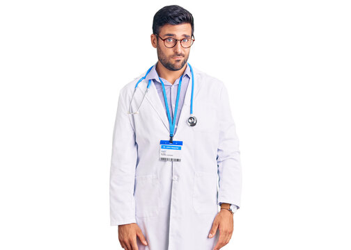 Young hispanic man wearing doctor uniform and stethoscope skeptic and nervous, frowning upset because of problem. negative person.