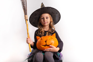  little girl in halloween costume holding a pumpkin in her hands on a white background