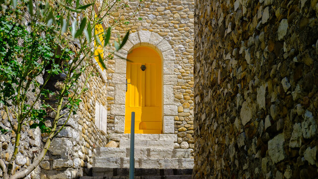 medieval street with yellow shutters and door at Montpezat 