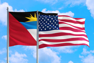 United States and Antigua and Barbuda national flag waving in the windy deep blue sky. Diplomacy and international relations concept.