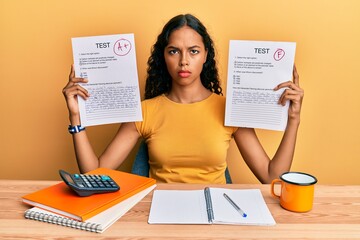 Young african american girl showing failed and passed exam skeptic and nervous, frowning upset...