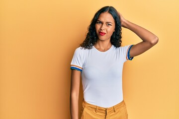 Obraz premium Young african american girl wearing casual clothes confuse and wonder about question. uncertain with doubt, thinking with hand on head. pensive concept.