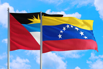 Venezuela and Antigua and Barbuda national flag waving in the windy deep blue sky. Diplomacy and international relations concept.