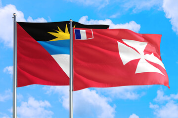 Wallis And Futuna and Antigua and Barbuda national flag waving in the windy deep blue sky. Diplomacy and international relations concept.