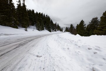 Obraz premium Snowy mountain road streching through the hills
