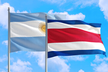 Costa Rica and Argentina national flag waving in the windy deep blue sky. Diplomacy and international relations concept.