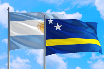 Curacao and Argentina national flag waving in the windy deep blue sky. Diplomacy and international relations concept.
