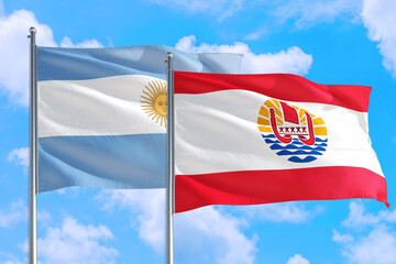 French Polynesia and Argentina national flag waving in the windy deep blue sky. Diplomacy and international relations concept.