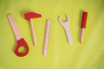 Toy wooden tools on a bright green background