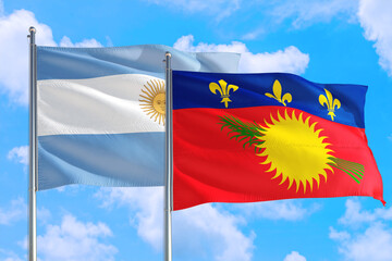 Guadeloupe and Argentina national flag waving in the windy deep blue sky. Diplomacy and international relations concept.