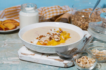 healthy smoothie bowl with mango, coconut and nuts for breakfast