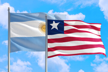 Liberia and Argentina national flag waving in the windy deep blue sky. Diplomacy and international relations concept.