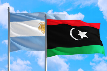 Libya and Argentina national flag waving in the windy deep blue sky. Diplomacy and international relations concept.