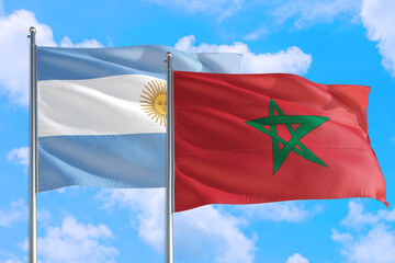Morocco and Argentina national flag waving in the windy deep blue sky. Diplomacy and international relations concept.