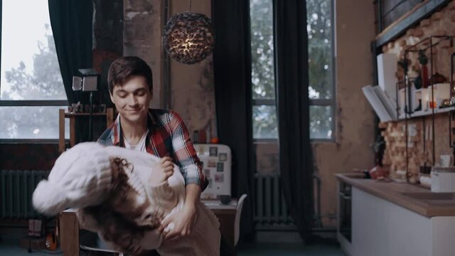 Crazy young couple dancing and having fun on Christmas evening. Brightly decorated living room decorated with bright Christmas tree lights. Happy winter holidays and hobby concept
