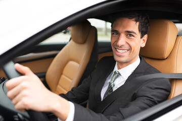 Smiling business man driving his new car