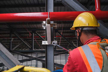 Install fire sprinkler system. In the industrial plant, pipe assembly, red fire pipe, fire protection contractors Using Scissor Lift High work - obrazy, fototapety, plakaty