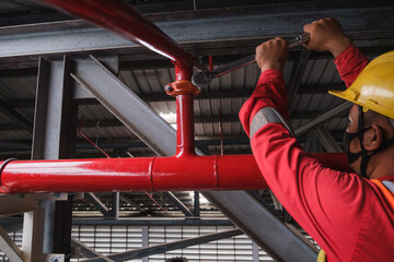 Install fire sprinkler system. In the industrial plant, pipe assembly, red fire pipe, fire protection contractors Using Scissor Lift High work - obrazy, fototapety, plakaty